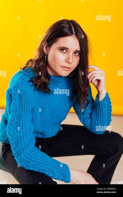 Portrait Of A Skinny Fashionable Brunette Woman In Jeans And A Blue
