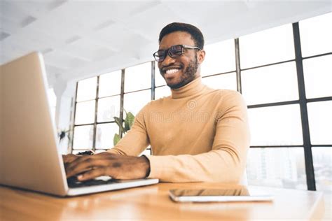 Smiling Black Guy At Flexible Office Typing On Keyboard Stock Photo