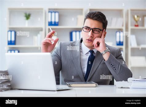 Businessman Smoking In Office At Work Stock Photo Alamy