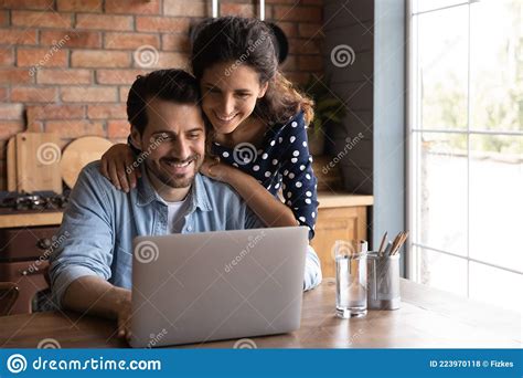 Feliz Esposa Milenaria Apoyando A Su Marido Que Trabaja En Una Laptop