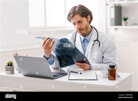 Serious Medical Doctor Studying Radiography At Office Stock Photo Alamy