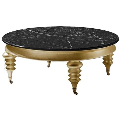 It is crafted from solid mango wood, with natural wood grain variations, and black iron accents. Rolling Gold Round Coffee Table with Black Marble Top and ...