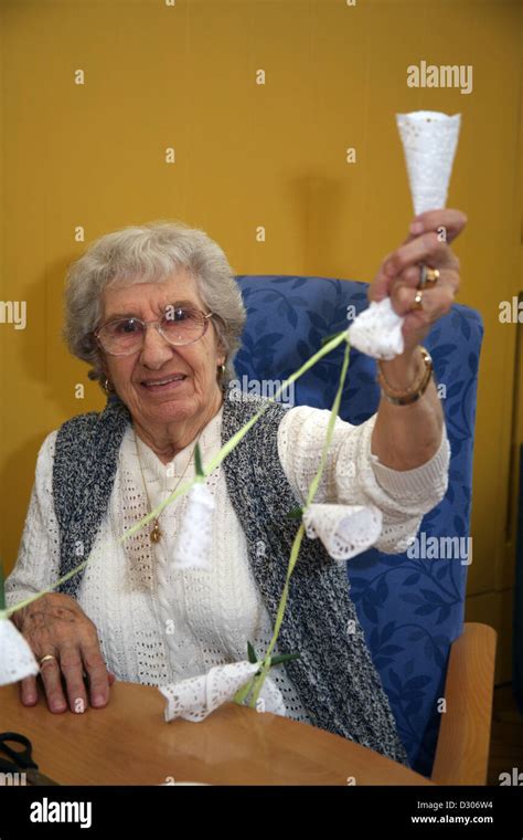 senior citizen enjoying craft class and making hanging decorations in a community centre stock