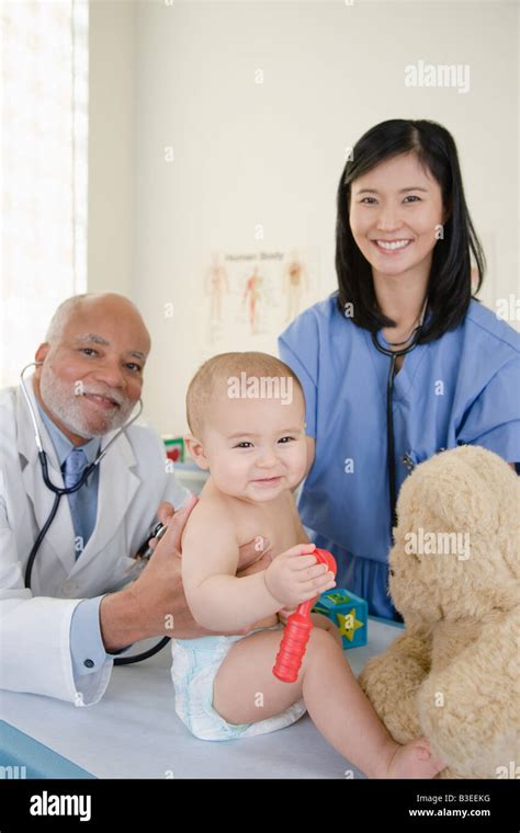 A Doctor And Nurse Examining A Baby Stock Photo Alamy