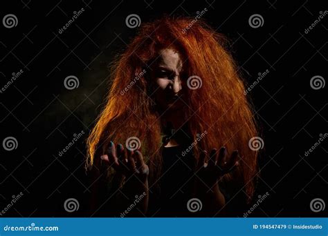 Portrait Of An Evil Red Haired Witch Conjures In The Dark Stock Image