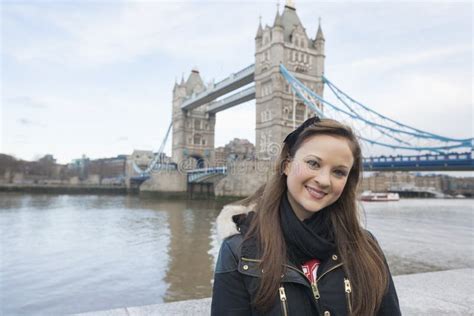 Portrait Of Beautiful Young Woman Standing In Front Of Tower Bridge