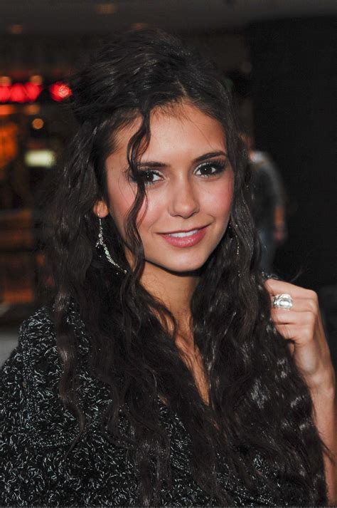 A Woman With Long Black Hair And Earrings