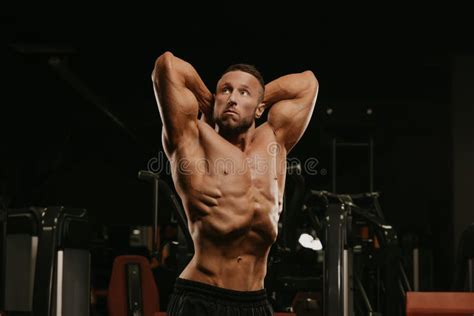 A Bodybuilder With A Beard Is Doing A Stomach Vacuum Pose During A