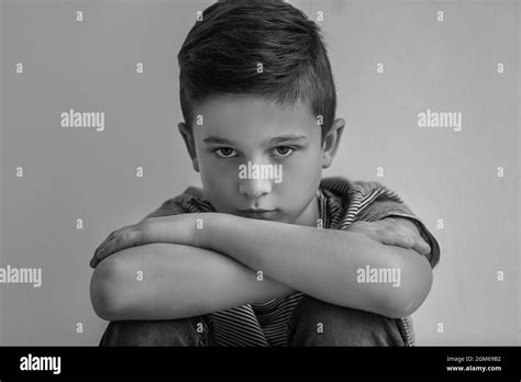 Sad Little Boy On Grey Background Black And White Effect Stock Photo