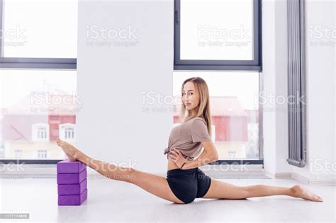 Young Awesome Fit Girl Holding Her Legs On The Pellows And Doing Splits