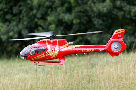 Red And White Helicopter Flying Over Green Grass Field · Free Stock Photo