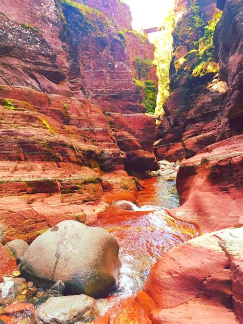 A River Flowing Through A Canyon Surrounded By Red Rocks