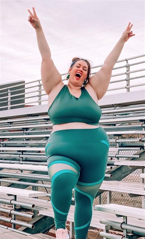 A Woman With Her Arms In The Air While Standing On Bleachers