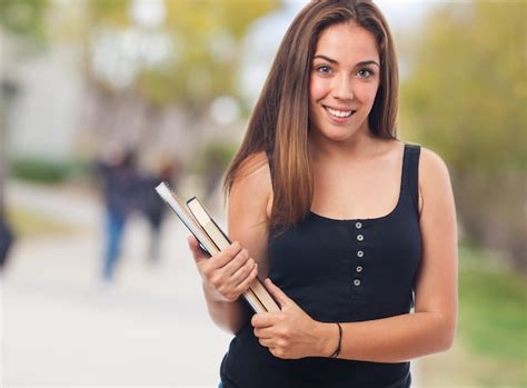 Estudiante Sonriente Sujetando Unos Libros Descargar Fotos Gratis