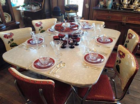 I tend to think that 1950s dinette sets were usually similar to the one above — laminate top, wrapped with aluminum edging, fat upholstered chairs. The prettiest vintage red dinette we've ever seen