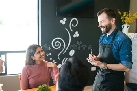 Waiter Taking Orders From People At Restaurant Stock Photo Image Of