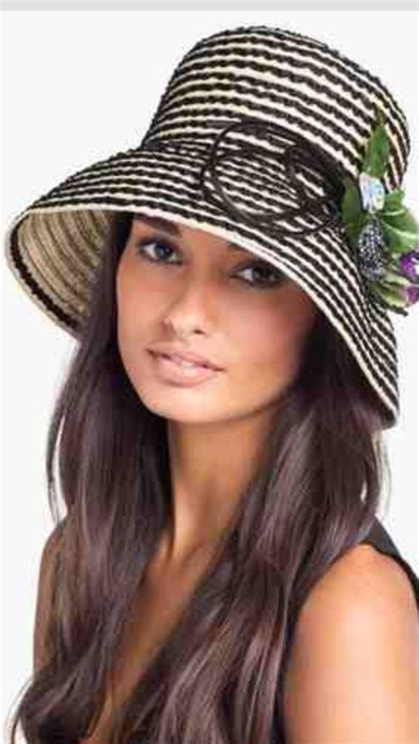 A Woman Wearing A Black And White Hat With Flowers On The Brimmed Top