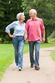 active and happy senior couple walking in the park - guerradental.com