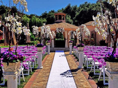 an outdoor wedding setup with purple and white flowers