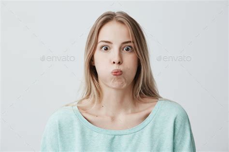 Portrait Of Shocked Astonished Young Blonde Woman With Popped Eyes