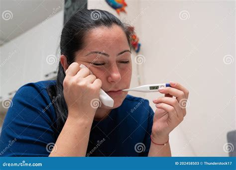Female Model Checking Body Temperature Using Thermometer Stock Image