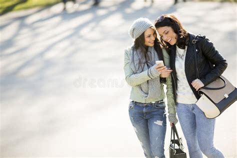 Two Beautiful Young Women Walking And Talking In The Stock Photo