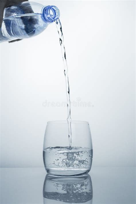A High Stream Of Clean Drinking Water Flows From The Bottle Into A