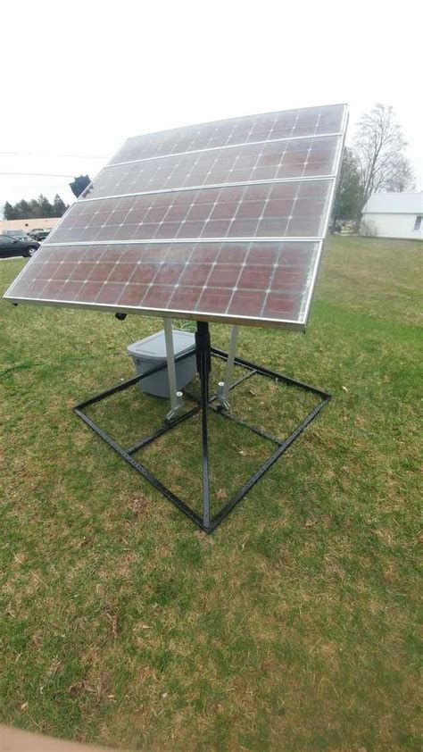 A Solar Panel On Top Of A Metal Stand In The Middle Of A Grassy Field