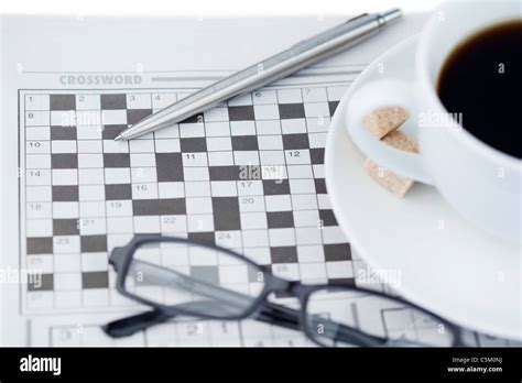 A Cup Of Coffee A Pen A Pair Of Glasses And A Crossword Puzzle Stock