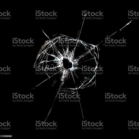 Hole With Cracks In The Glass Isolated On A Black Stock Photo