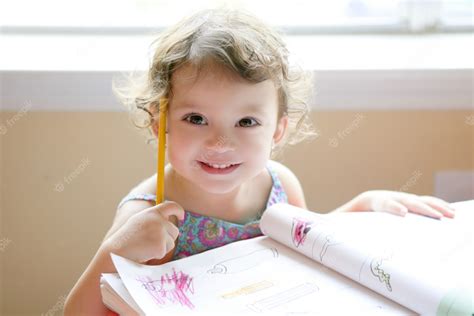Menina Da Criança Pequena Escrevendo Na Mesa Da Escola Foto Premium