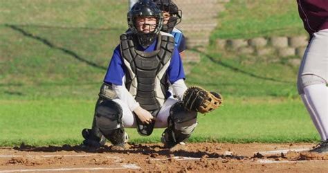 Caucasian Female Baseball Player In Catcher Position Catching Ball On