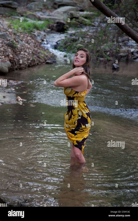 Pretty Woman In Yellow Dress Wading In A Shallow Creek Stock Photo Alamy