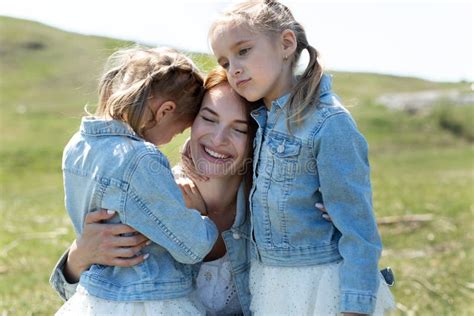 Retrato De Una Madre Y Dos Hijas Gemelas Abrazando Y Sonriendo En La