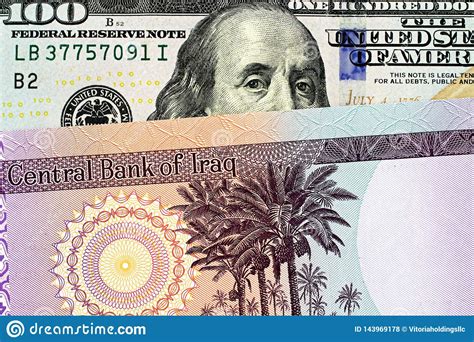 An Iraqi Fifty Dinar Bank Note With An American One Hundred Dollar Bill