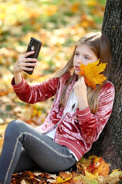 Premium Photo Beautiful Girl Taking Selfie By Smartphone At Autumn Park