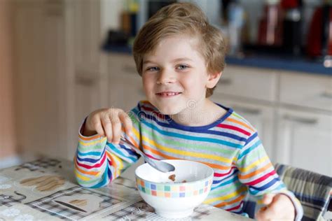 Happy Little Blond Kid Boy Eating Cereals For Breakfast Or Lunch