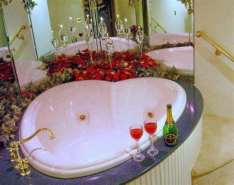 A Bathtub With Wine Glasses And Roses On The Counter