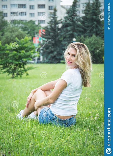 Portrait Of A Beautiful Girl In Denim Shorts And A White T Shirt Stock