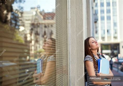 Exhausted Young Businesswoman With Eyes Closed Leaning On Wall — 20s