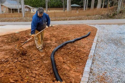 A Worker Digs A Trench In Order To Lay Drainage Pipes For Rainwater