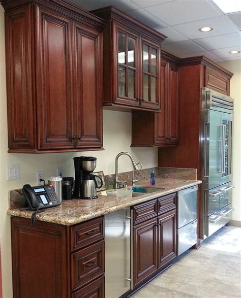 A Kitchen With Wooden Cabinets And Stainless Steel Appliances In The Center Along With Marble