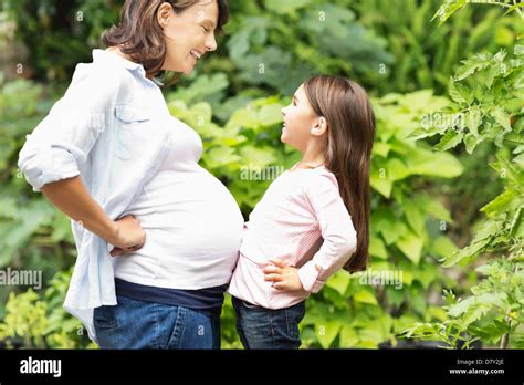 Girl Bumping Pregnant Mothers Belly Stock Photo Alamy