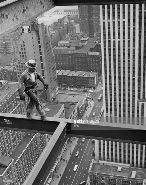 A New York Construction Worker Walks Along A Girder High Above The