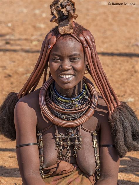 An African Woman With Large Braids On Her Head And Necklaces Around Her