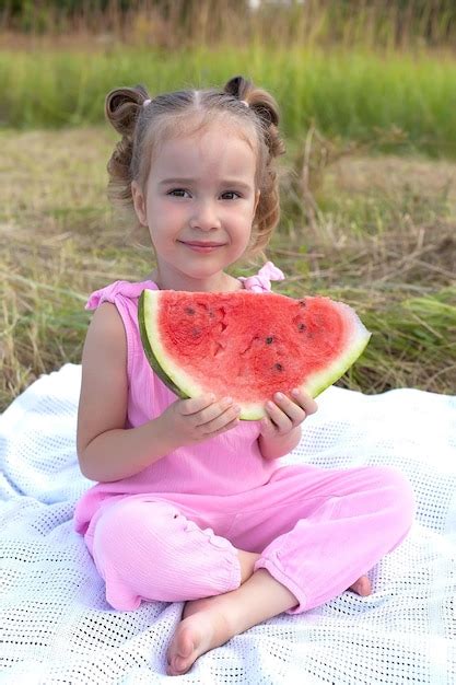 Premium Photo Cute Little Girl Eating Watermelon On The Grass In