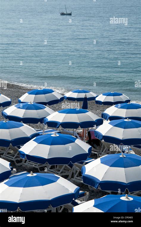 Looking Down At Rows Of Blue And White Beach Umbrellas On The Shoreline