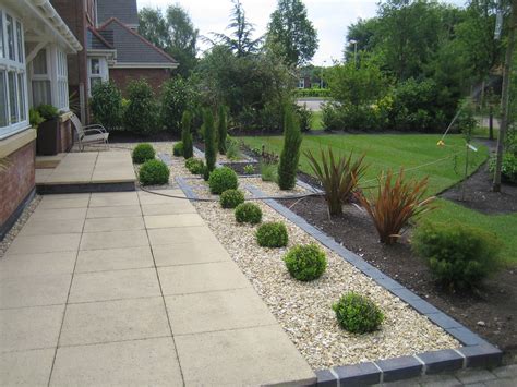 This is how to small garden ideas can be quite subtle. Marshalls Saxon paving with golden gravel and blue/black ...