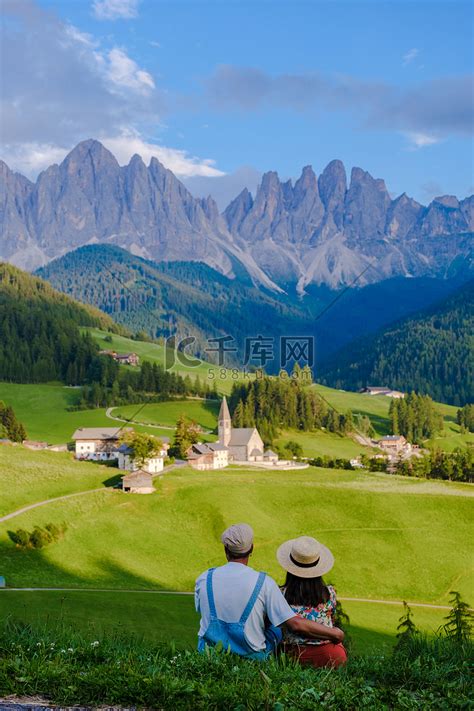 一对夫妇正在欣赏意大利南蒂罗尔州 Val Di Funes 的 Santa Maddalena Village 景观高清摄影大图 千库网