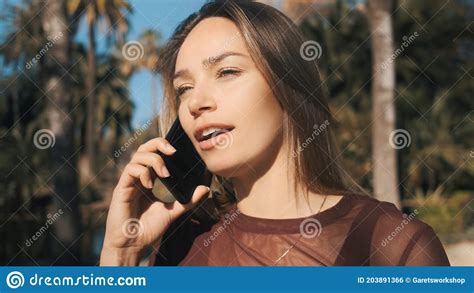 Attractive Girl Arguing With Friend During Talk On Phone In City Park